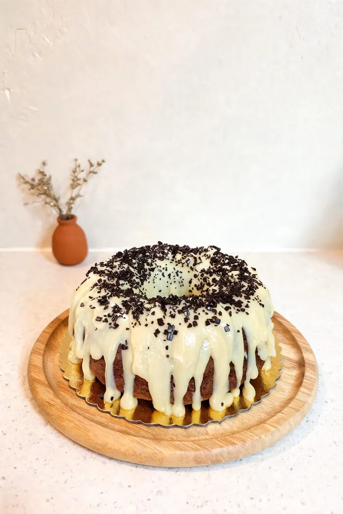 Torta con baño de chocolate blanco sobre tabla de madera